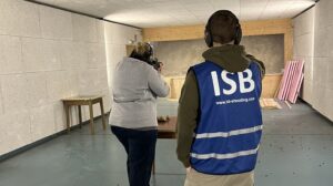Frau schießt auf Wettkampf ISB Schießstandaufsicht cropped